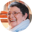 Happy elderly woman laughing sitting on sofa